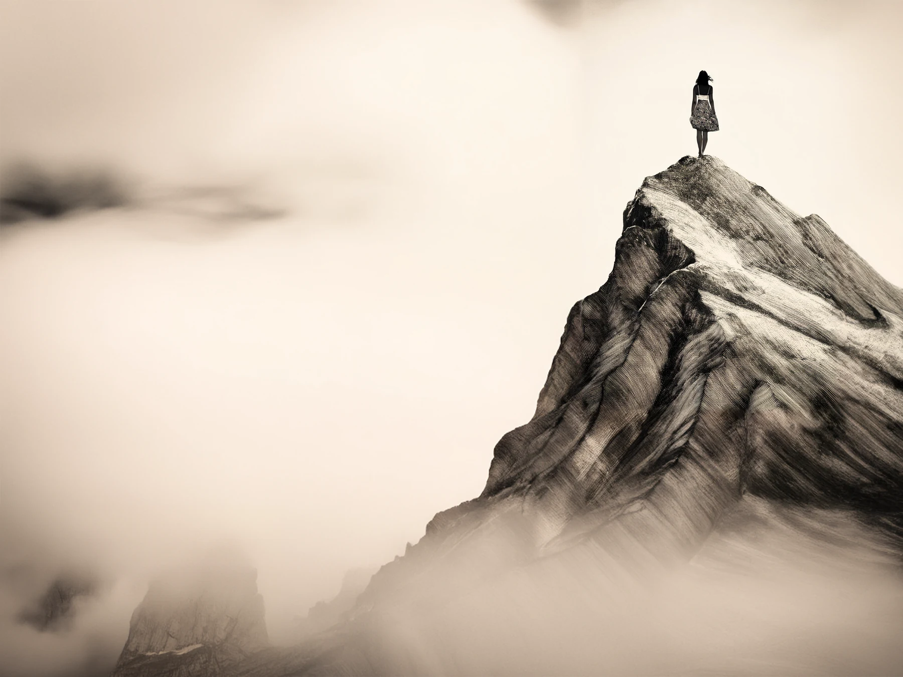 Une silhouette solitaire au sommet d’une montagne.
